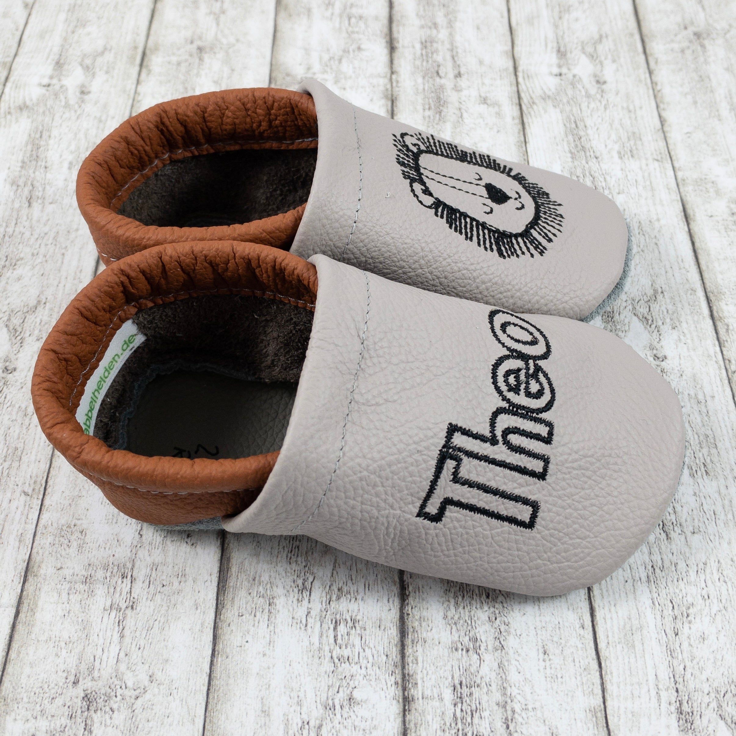 Krabbelschuhe in hellgrau mit Löwe und Name bestickt