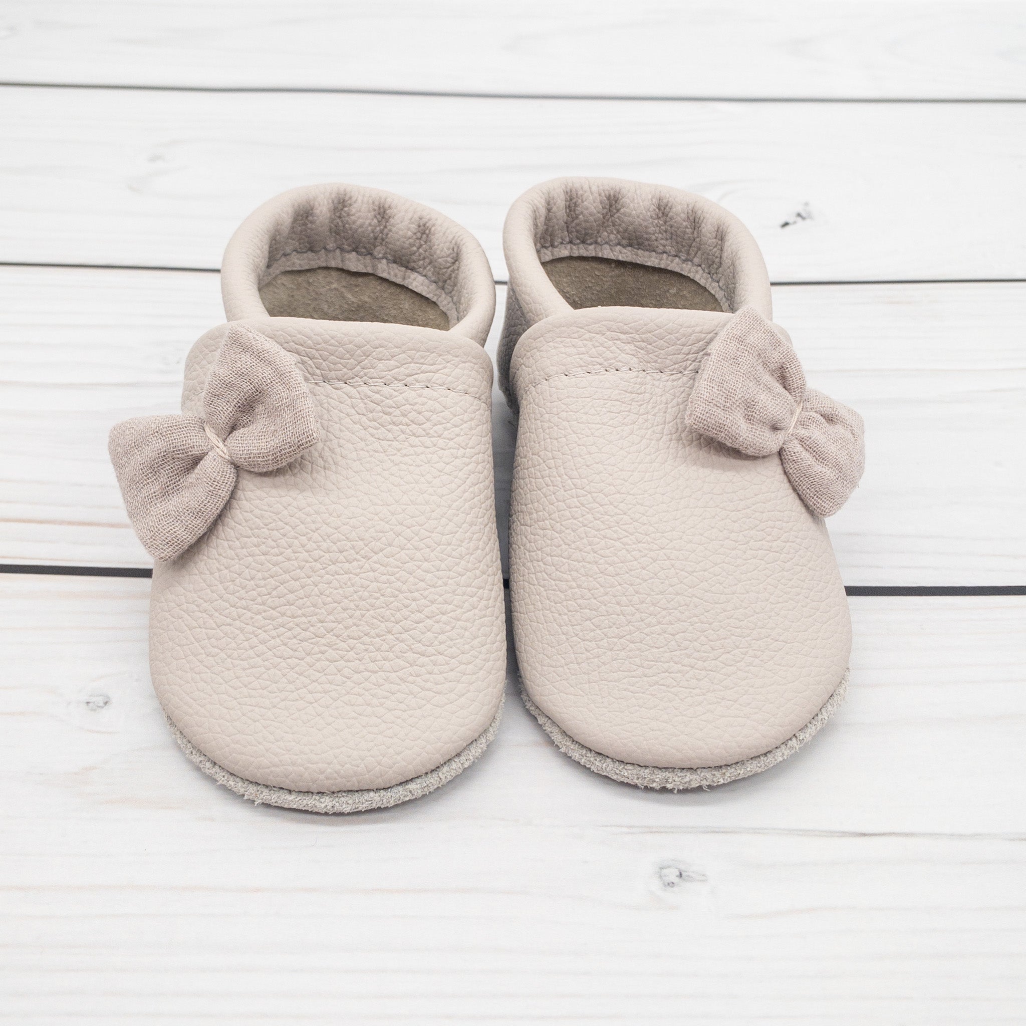 Krabbelschuhe in hellgrau mit kleinen Schleifen aus Musselin