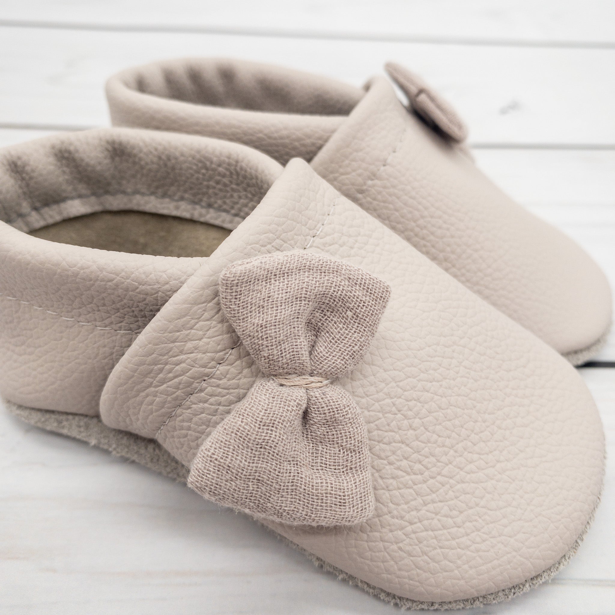 Krabbelschuhe in hellgrau mit kleinen Schleifen aus Musselin