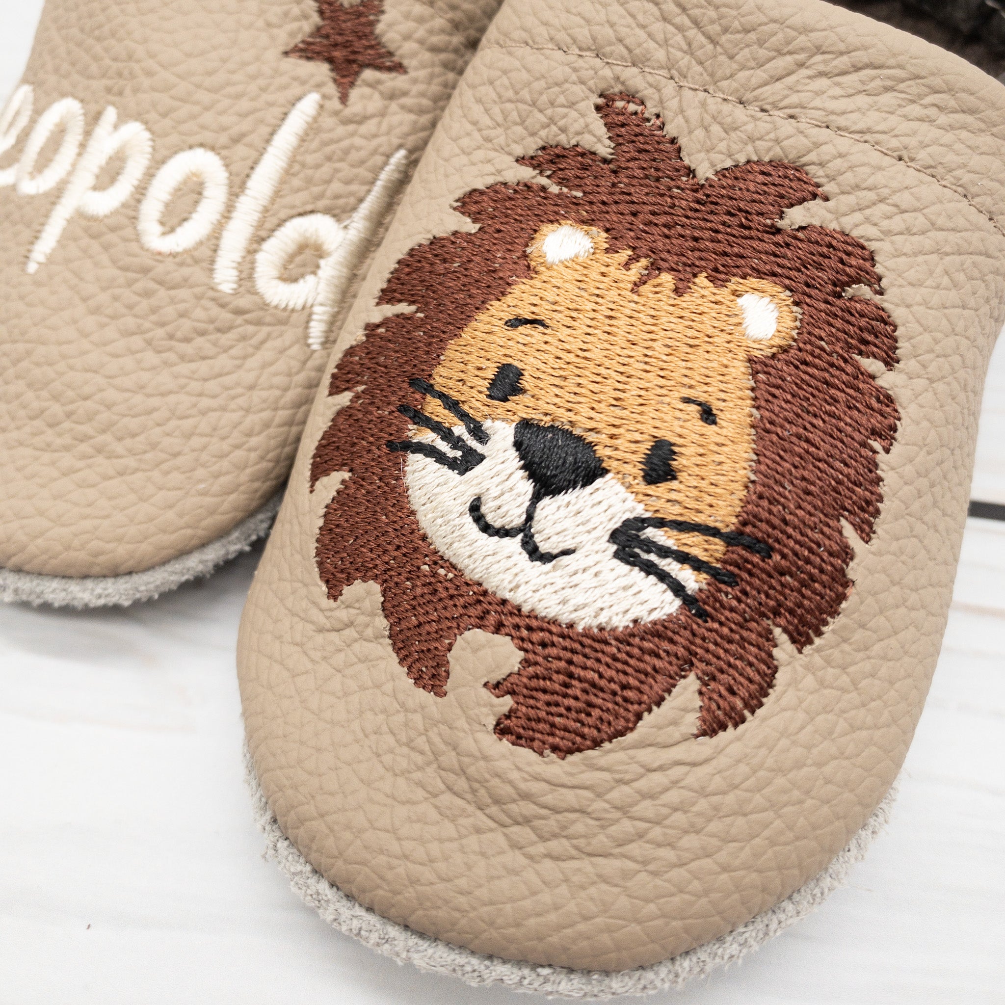 Krabbelschuhe in camel und dunkelbraun mit Löwe und Name bestickt