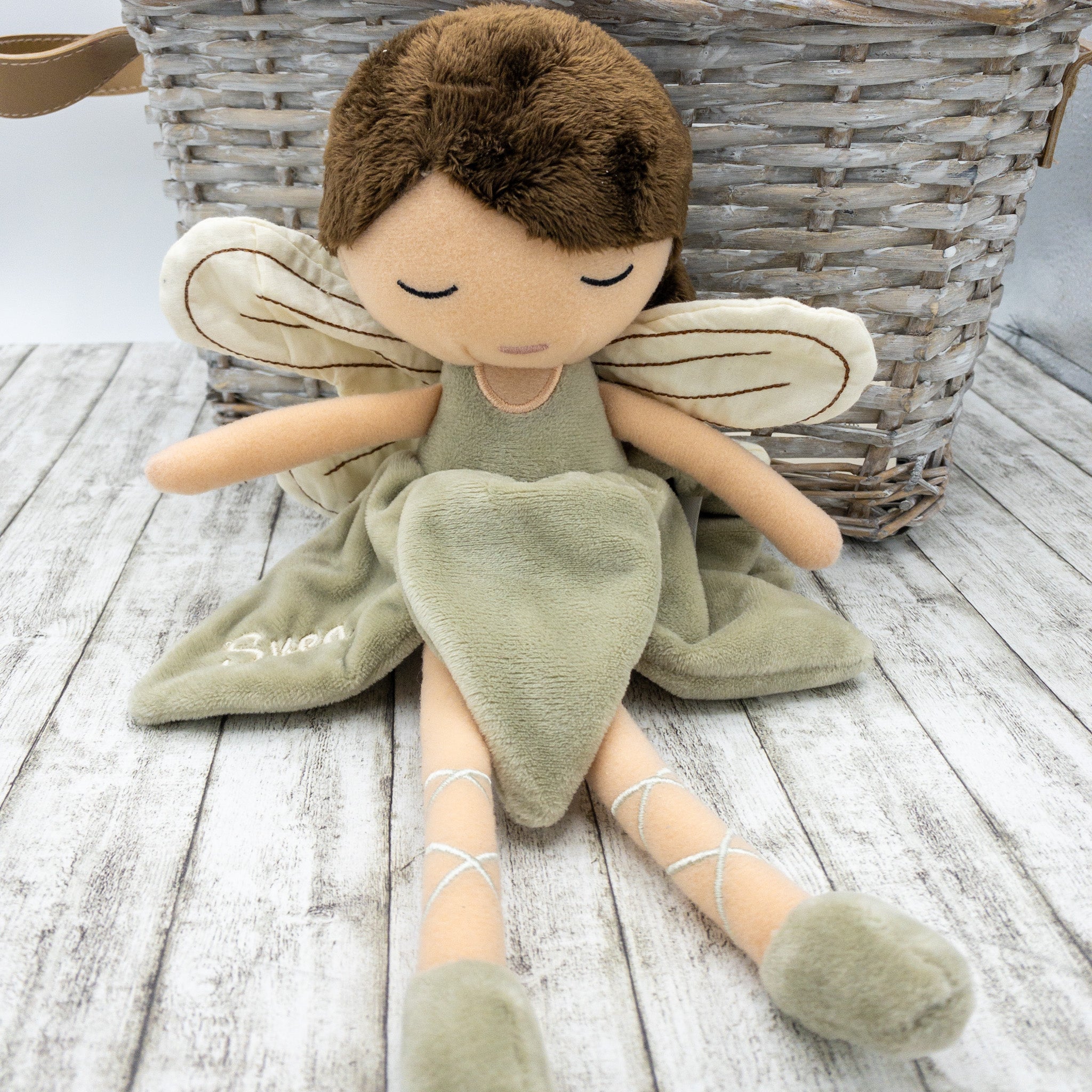 Handgefertigte Feenpuppe aus weichem Stoff in Beige, mit filigranen Flügeln, gesticktem Namen “Lea” auf dem Kleid, braunen Haaren und liebevollen Details wie Ballerinaschuhen. Ideal als personalisiertes Geschenk für Kinder.