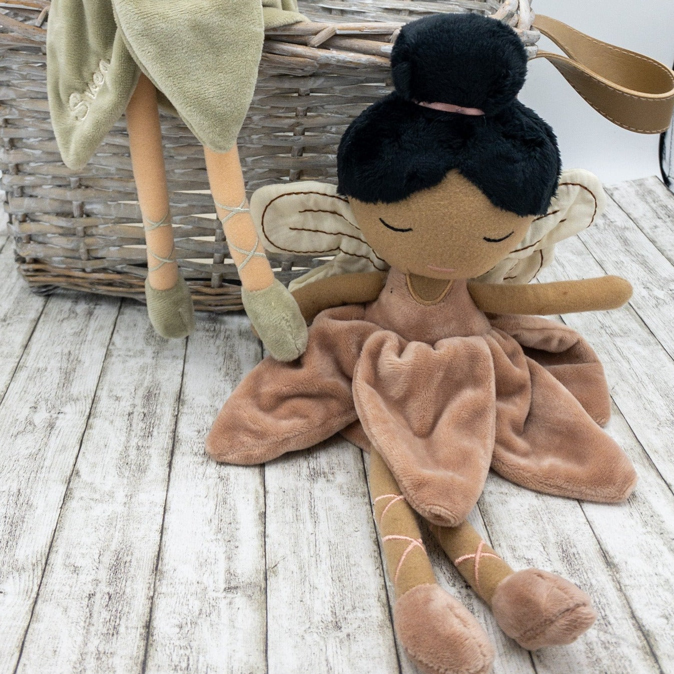 Handgemachte Feenpuppe aus weichem Stoff in einem zarten Rosaton, mit Flügeln, gesticktem Namen auf dem Kleid und liebevollen Details wie Ballerinaschuhen und einer Hochsteckfrisur. Perfekt als personalisiertes Geschenk für Kinder.