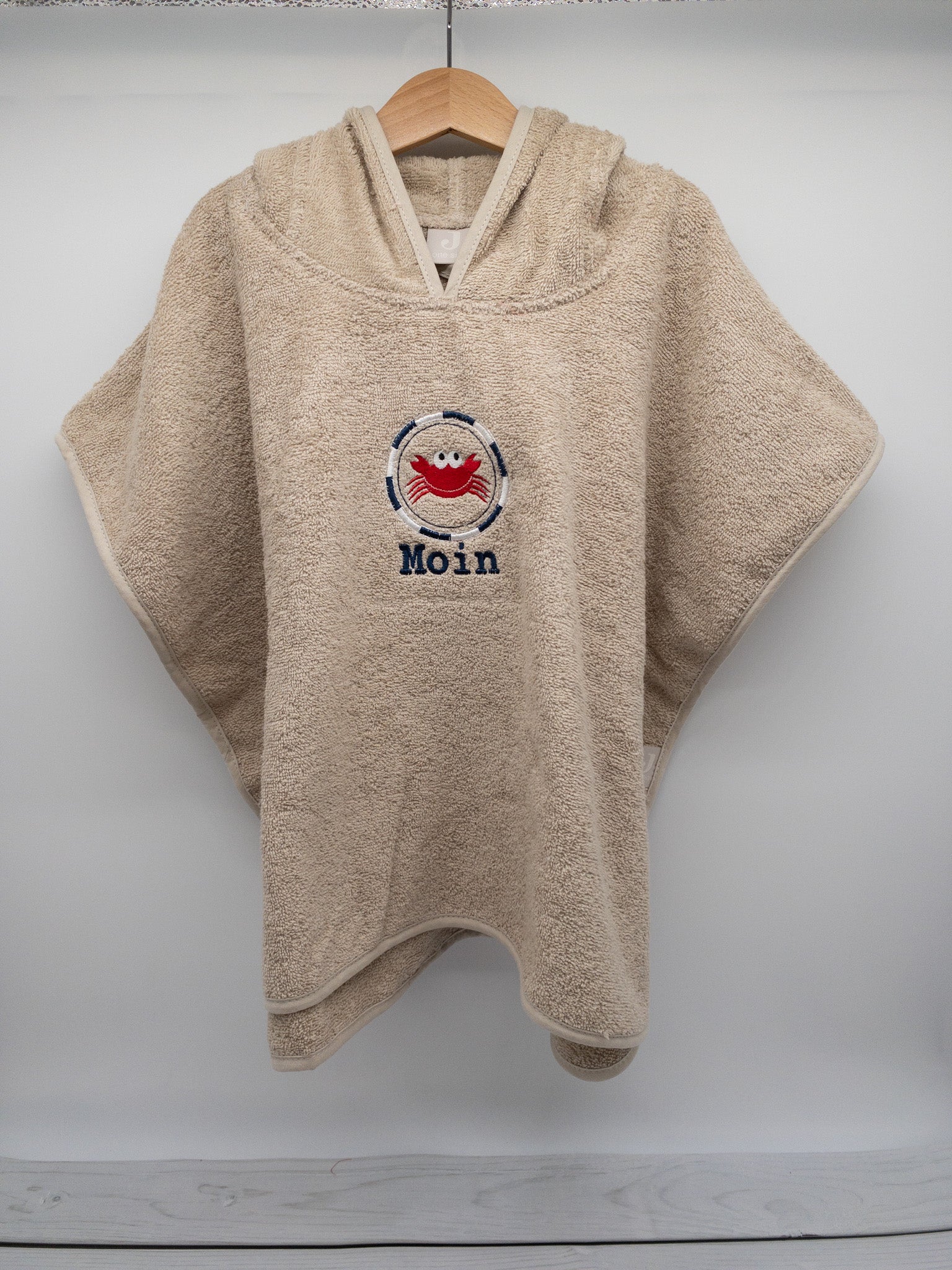 Badeponcho von Krabbelhelden, beige mit Namen und Krebs bestickt-Hängend.