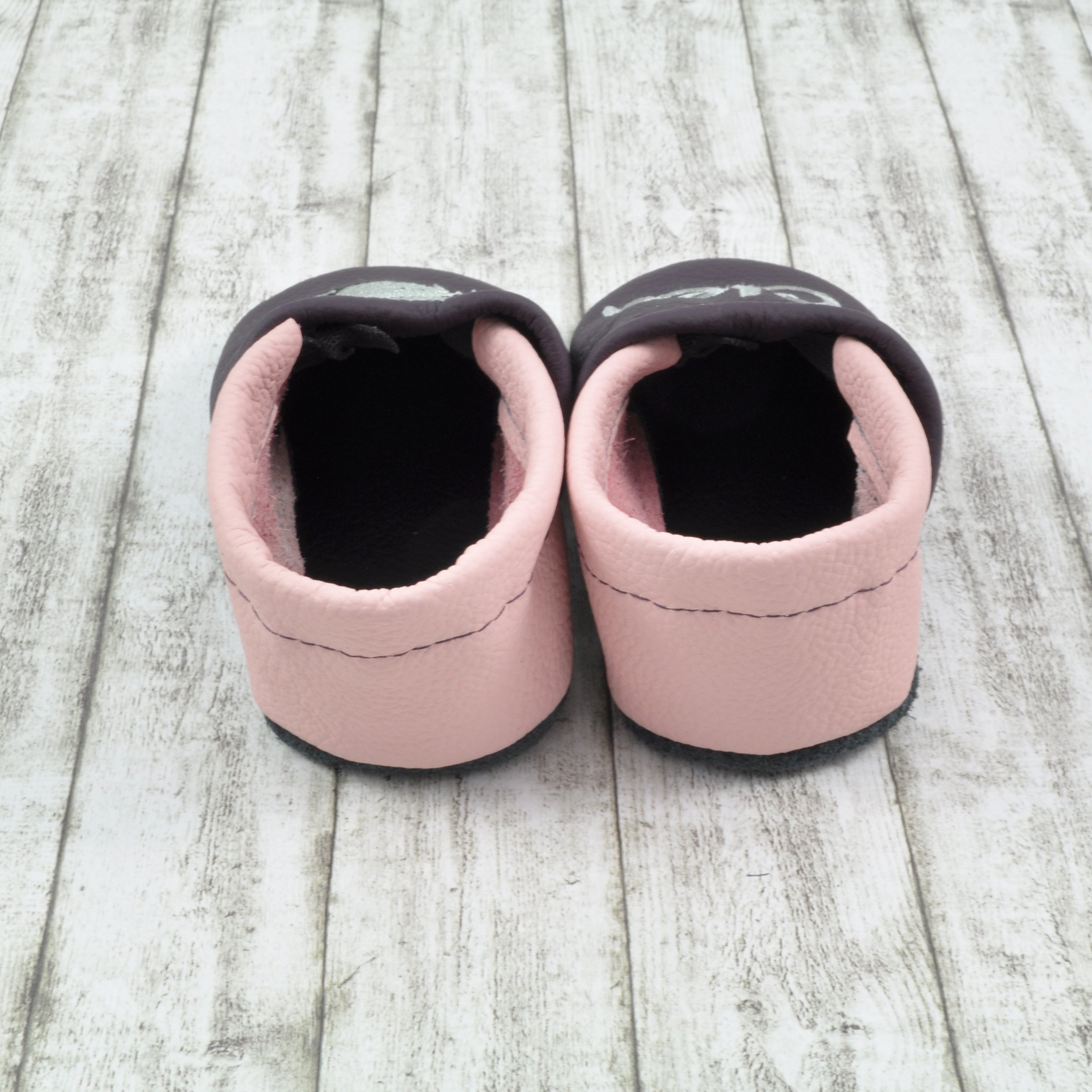 Weiche Krabbelschuhe von Krabbelhelden in lila und rosa mit Elefant und Name bestickt - von hinten gezeigt.