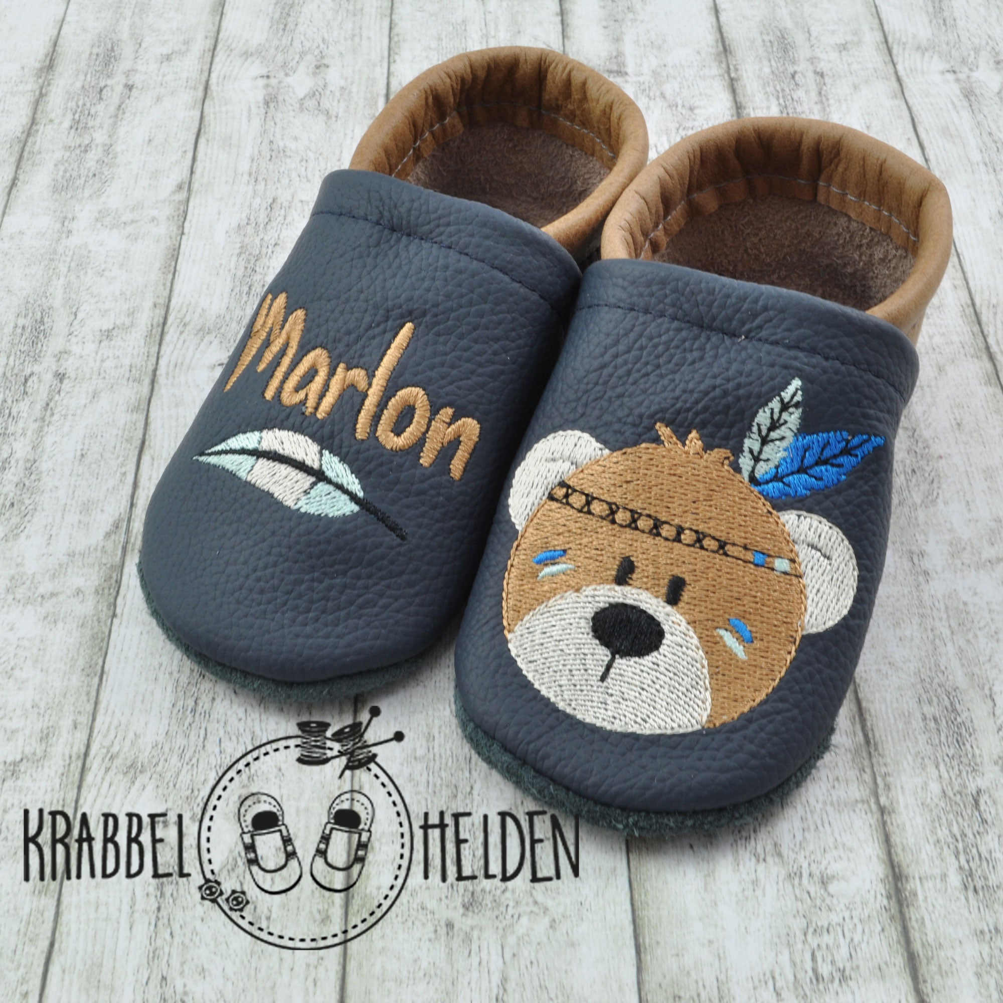 Krabbelschuhe von Krabbelhelden in grün und braun mit Bär und Federschmuck und Name bestickt.