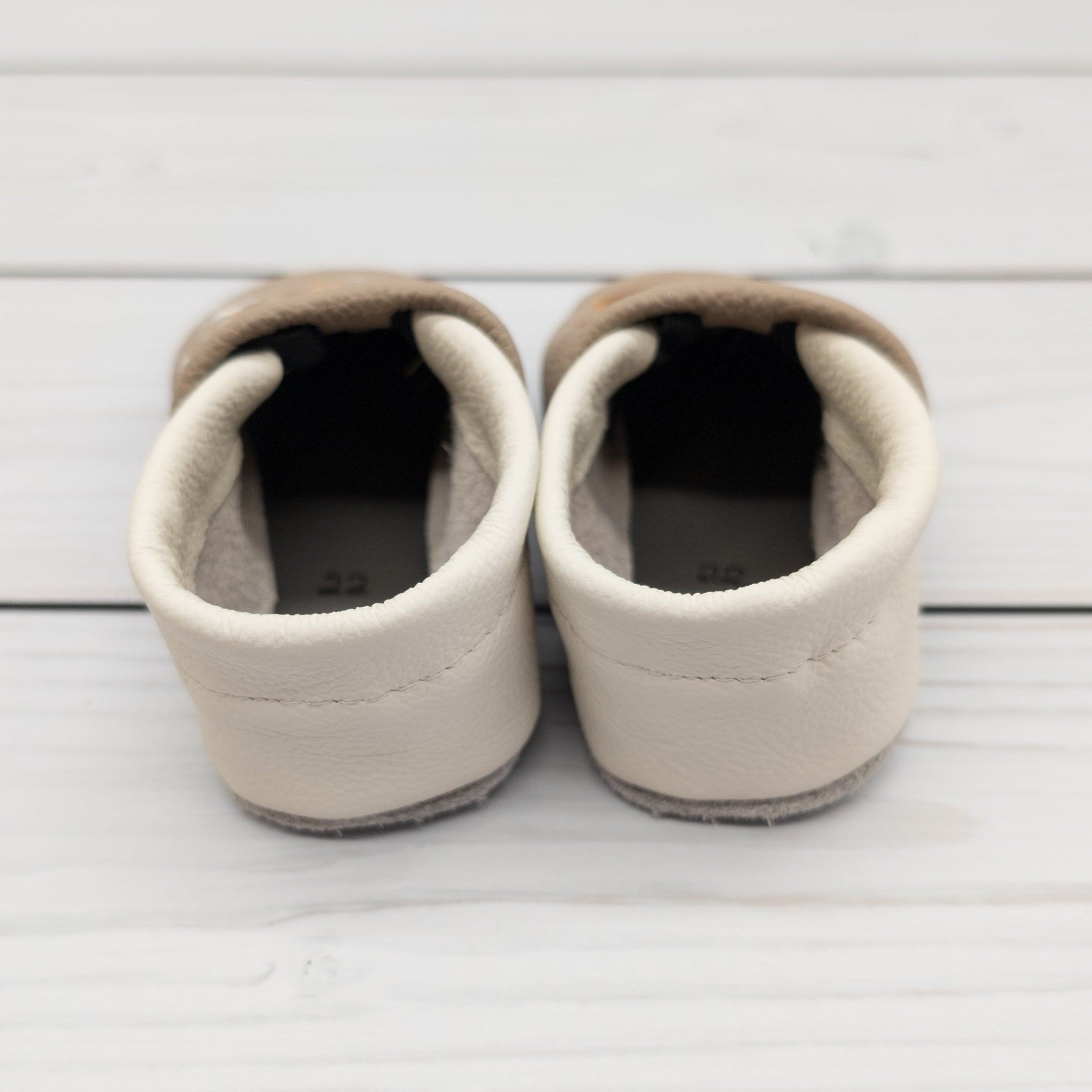 Hausschuhe aus Leder mit Giraffe und Name bestickt, von hinten gezeigt. Die Krabbelschuhe werden von Krabbelhelden in Deutschland hergestellt. www.krabbelhelden.de