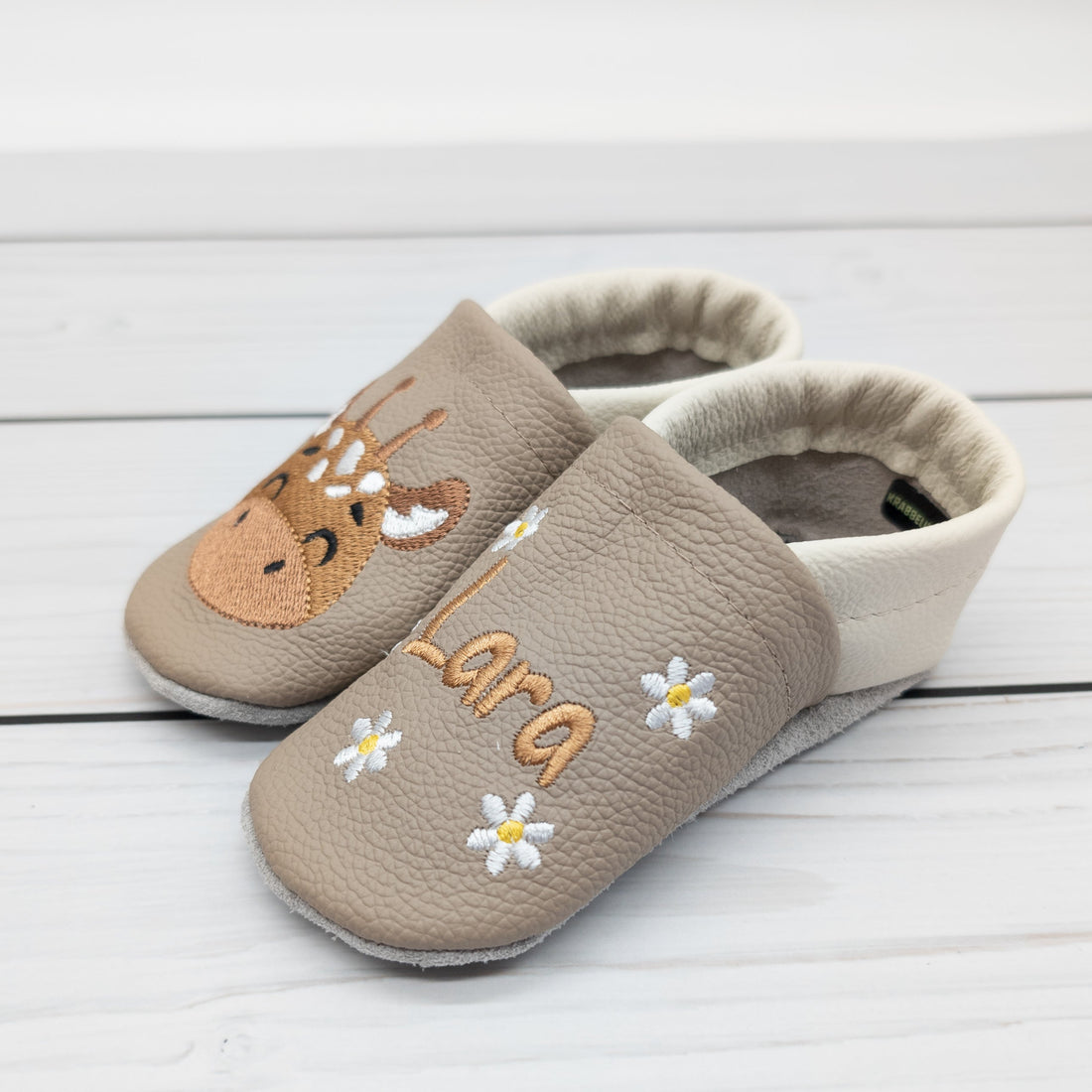 Hausschuhe aus Leder mit Giraffe und Name bestickt. Die Krabbelschuhe werden von Krabbelhelden in Deutschland hergestellt. www.krabbelhelden.de