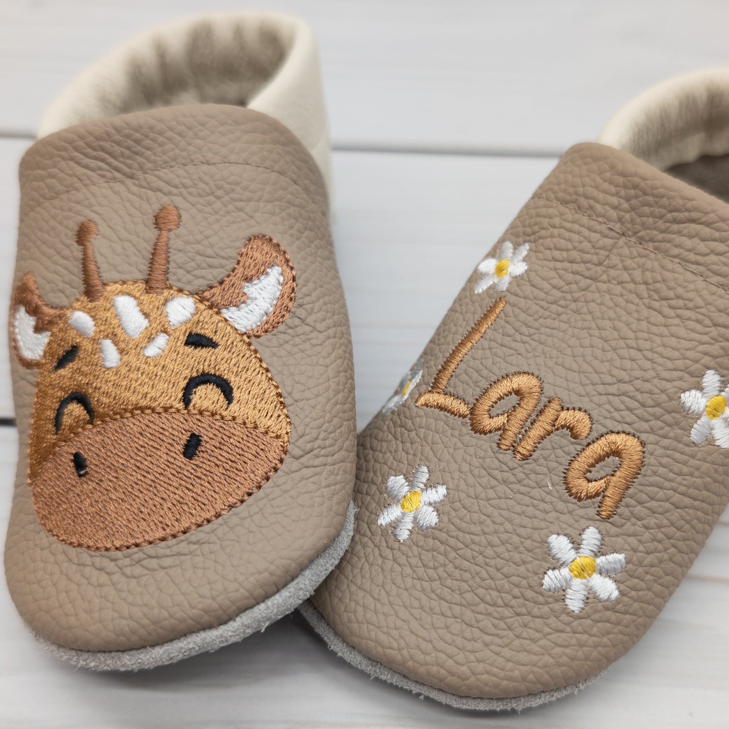 Hausschuhe aus Leder mit Giraffe und Name bestickt. Die Krabbelschuhe werden von Krabbelhelden in Deutschland hergestellt. www.krabbelhelden.de