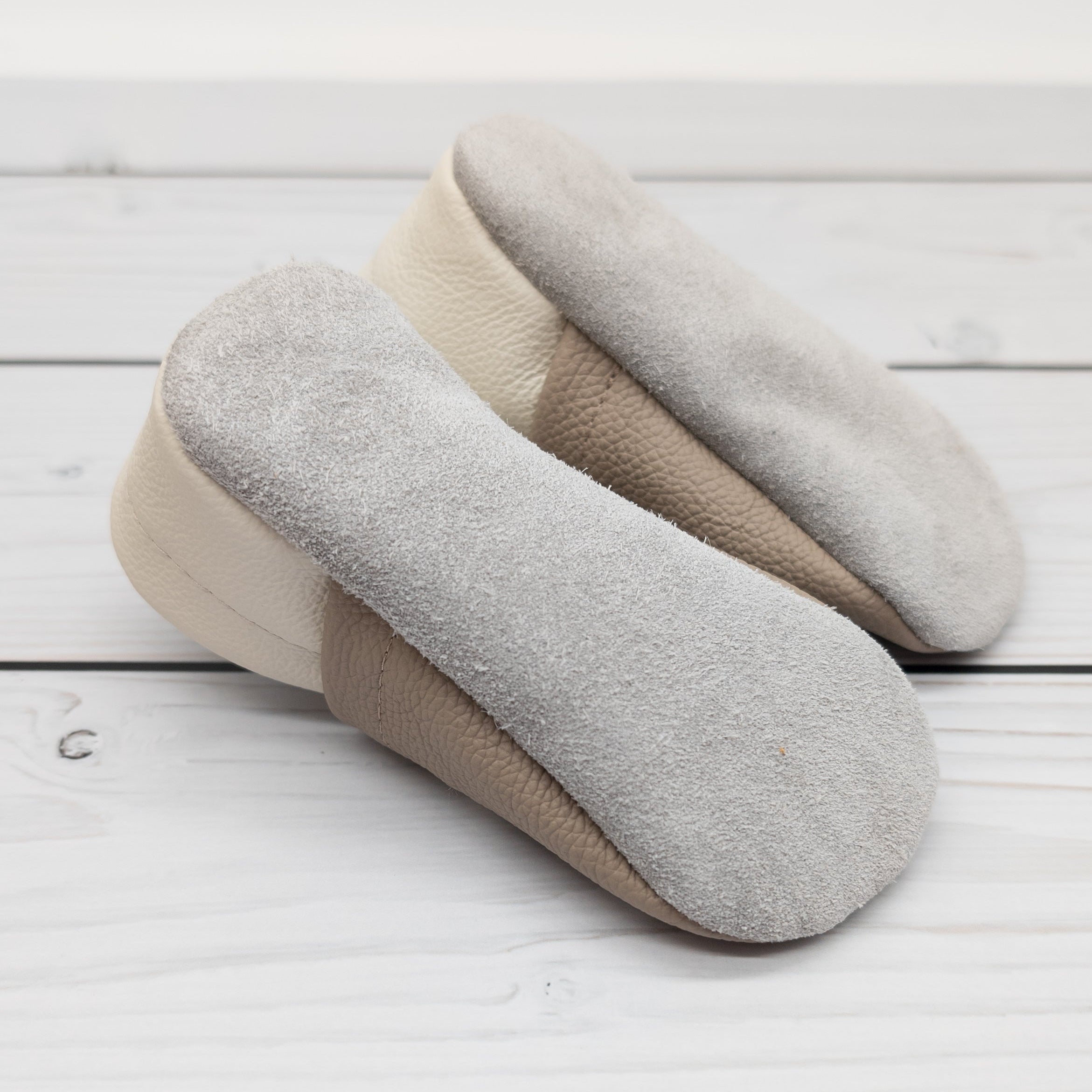 Hausschuhe aus Leder mit Giraffe und Name bestickt, von unten gezeigt mit rauher Sohle. Die Krabbelschuhe werden von Krabbelhelden in Deutschland hergestellt. www.krabbelhelden.de