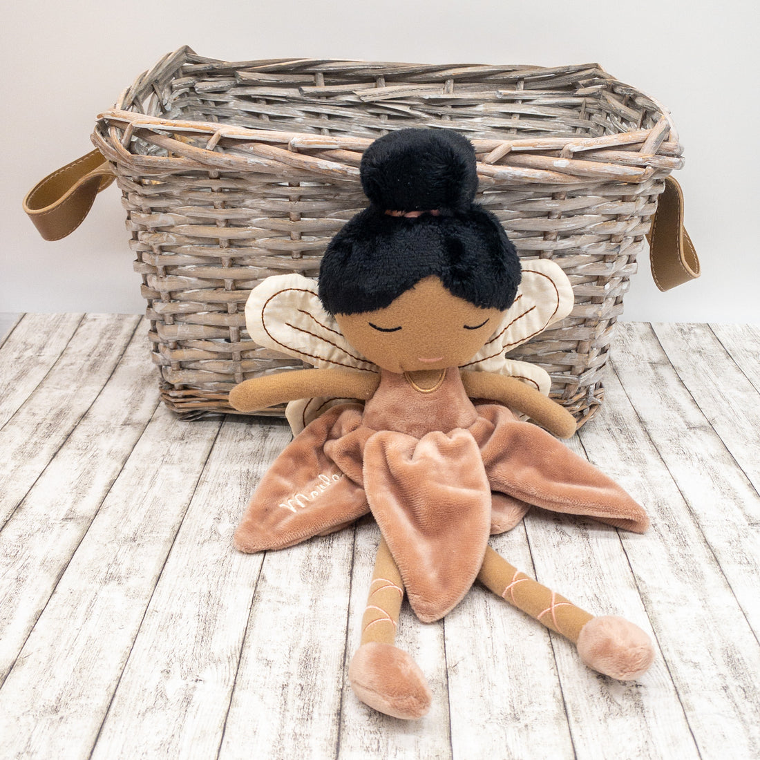 Handgemachte Feenpuppe aus weichem Stoff in einem zarten Rosaton, mit Flügeln, gesticktem Namen auf dem Kleid und liebevollen Details wie Ballerinaschuhen und einer Hochsteckfrisur. Perfekt als personalisiertes Geschenk für Kinder.