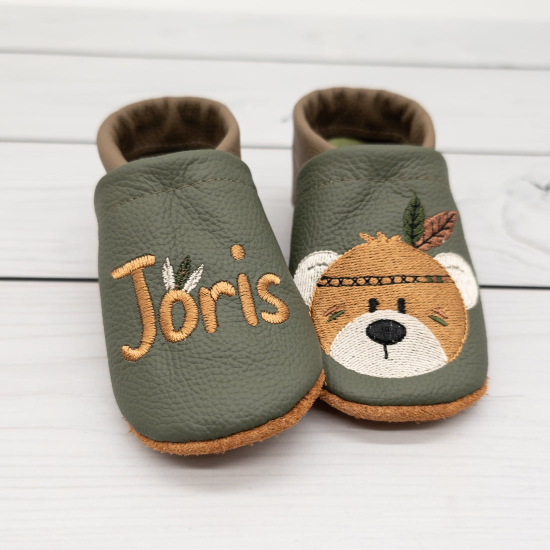 Krabbelschuhe von Krabbelhelden in grün und braun mit Bär und Federschmuck und Name bestickt.