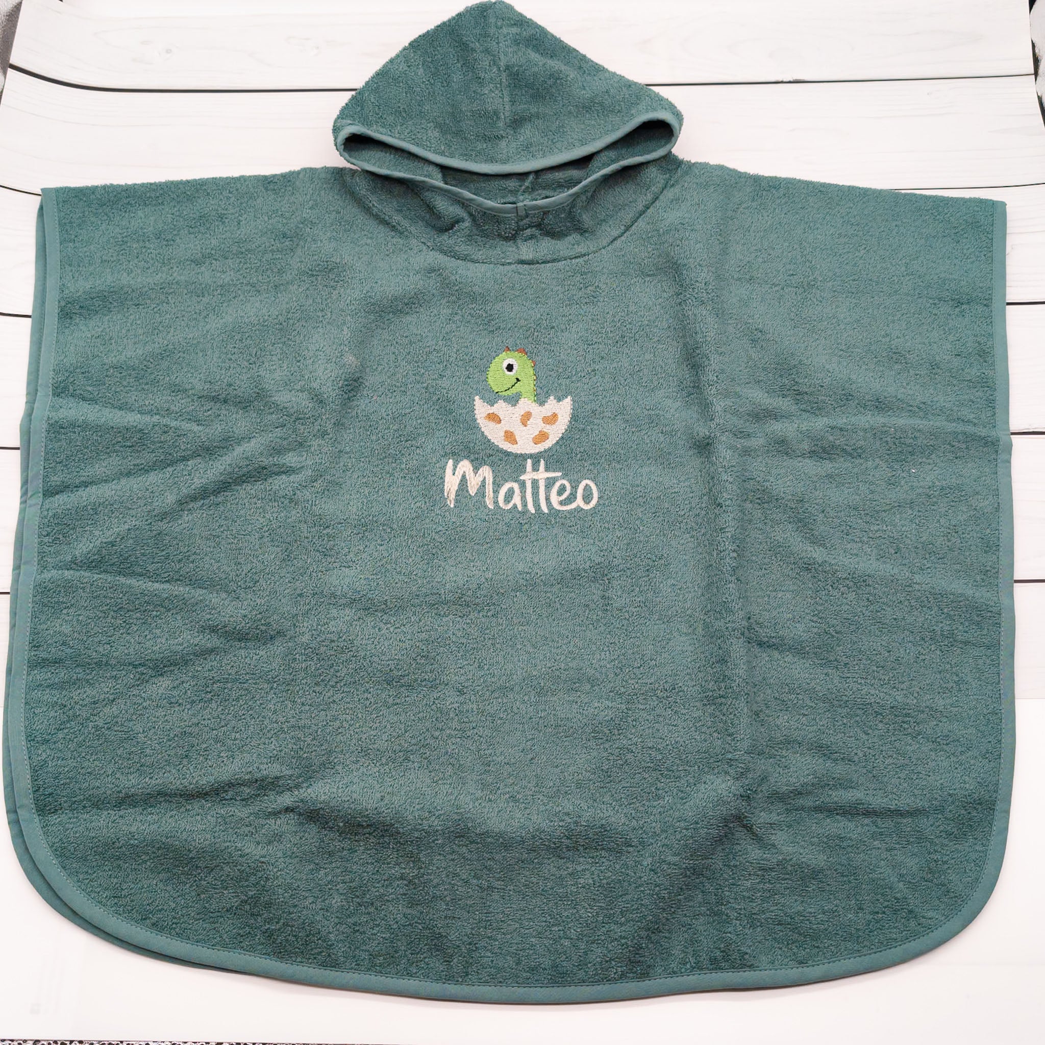 Badeponcho mit Dino im Ei und Namen - Ein richtig cooles Teil für die Badezeit und perfekt für den Strand – der Badeponcho darf einfach nicht fehlen