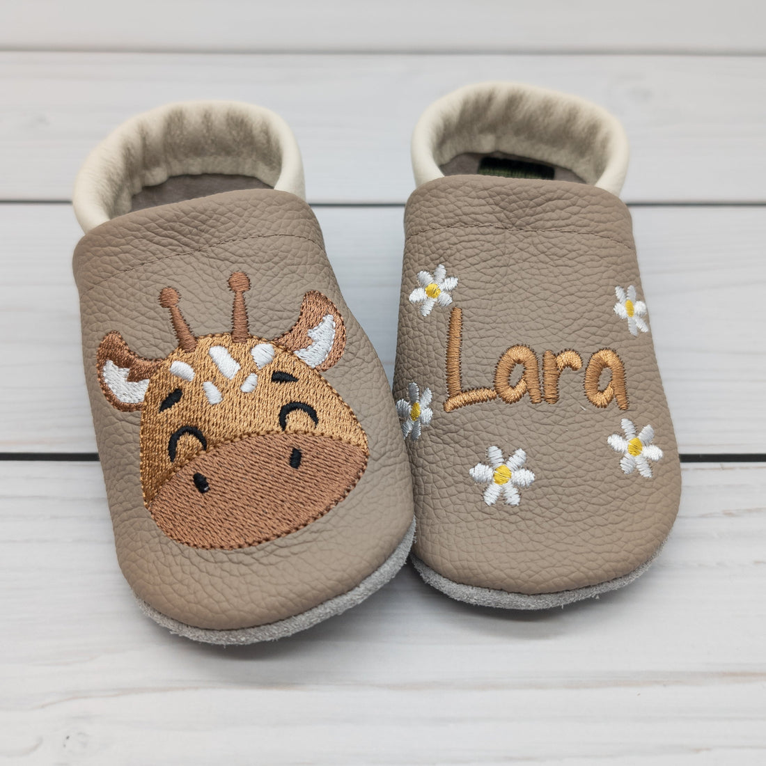 Hausschuhe aus Leder mit Giraffe und Name bestickt. Die Krabbelschuhe werden von Krabbelhelden in Deutschland hergestellt. www.krabbelhelden.de